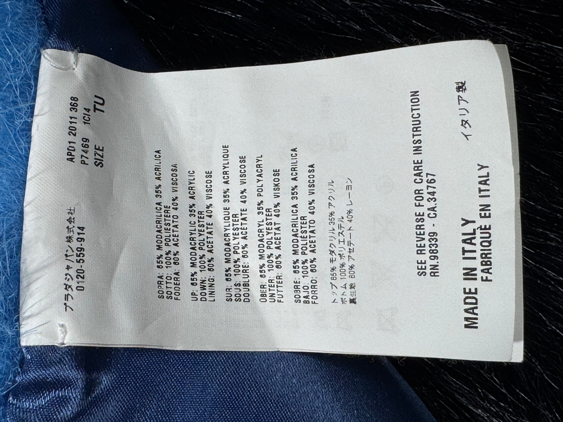 prada clothing label with text on a dark fabric background