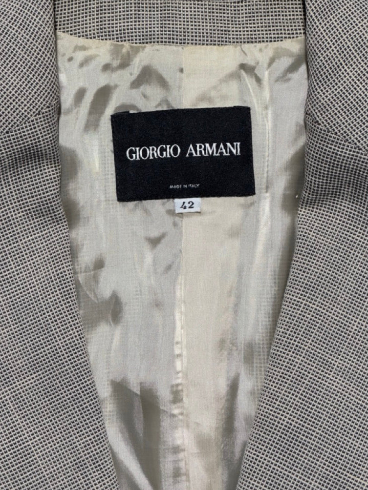 Gray suit jacket with Giorgio Armani label on a textured gray background