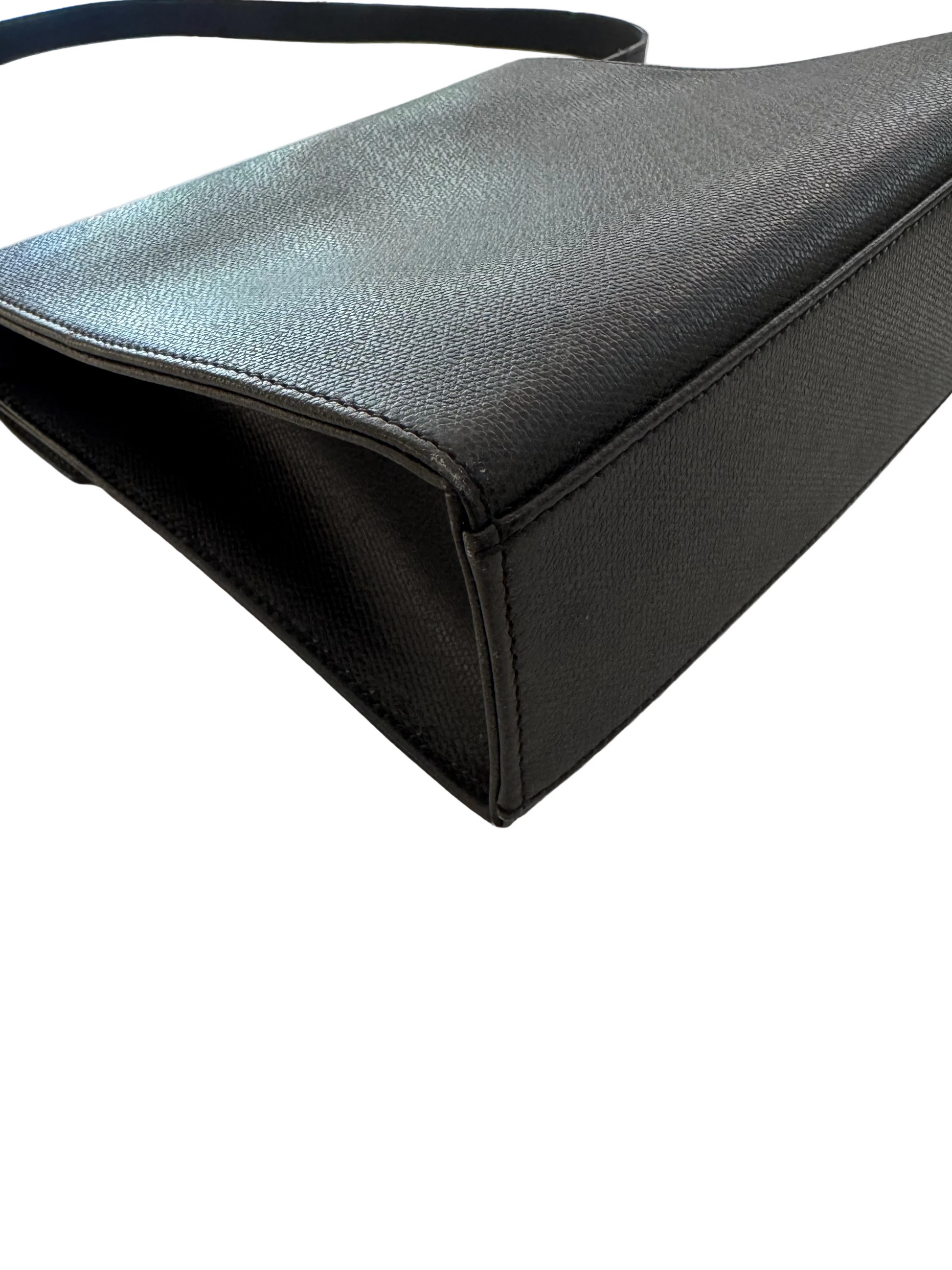 Black ysl handbag on a light gray surface