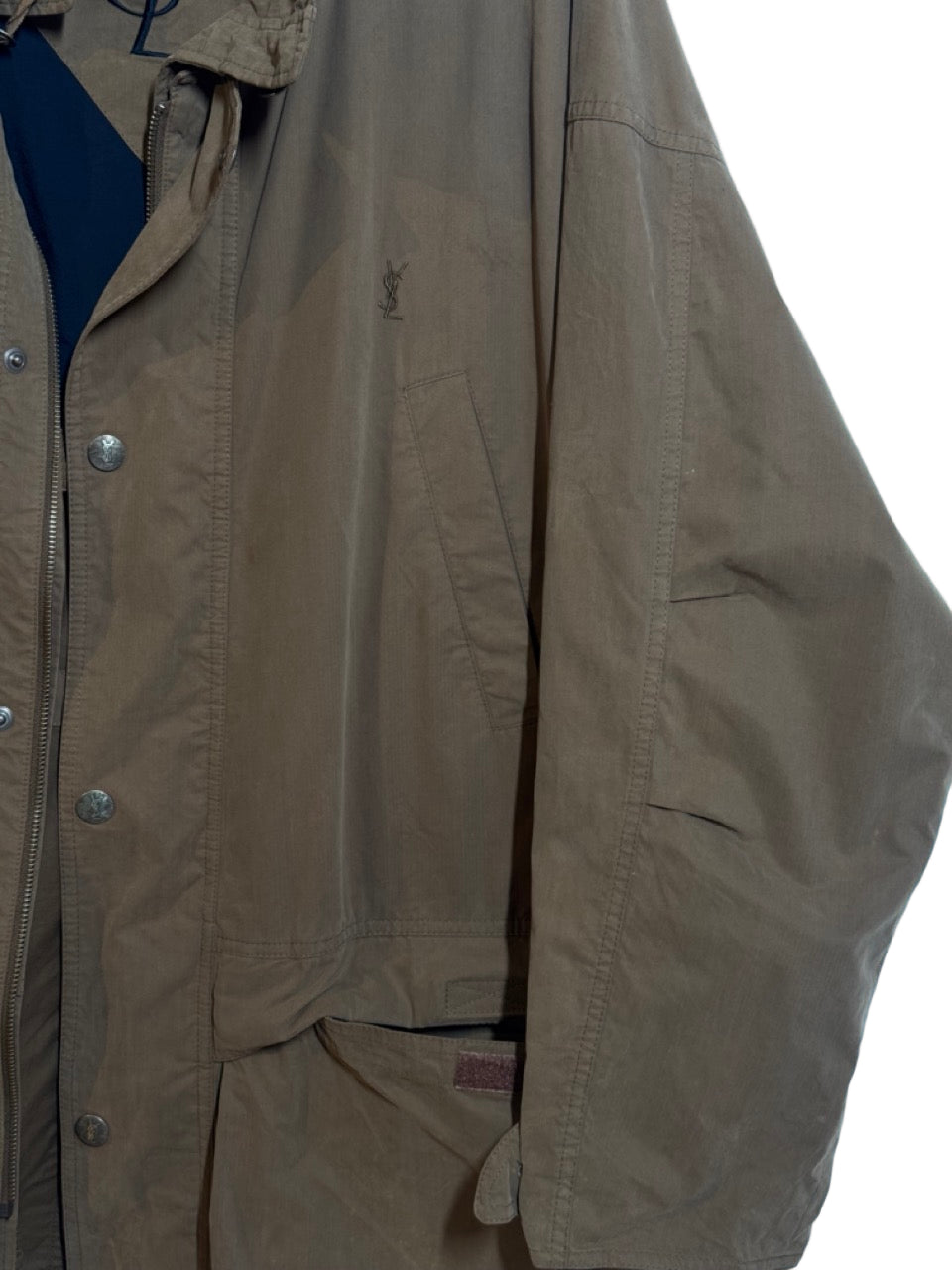 Beige jacket with brand logo on a light blue background