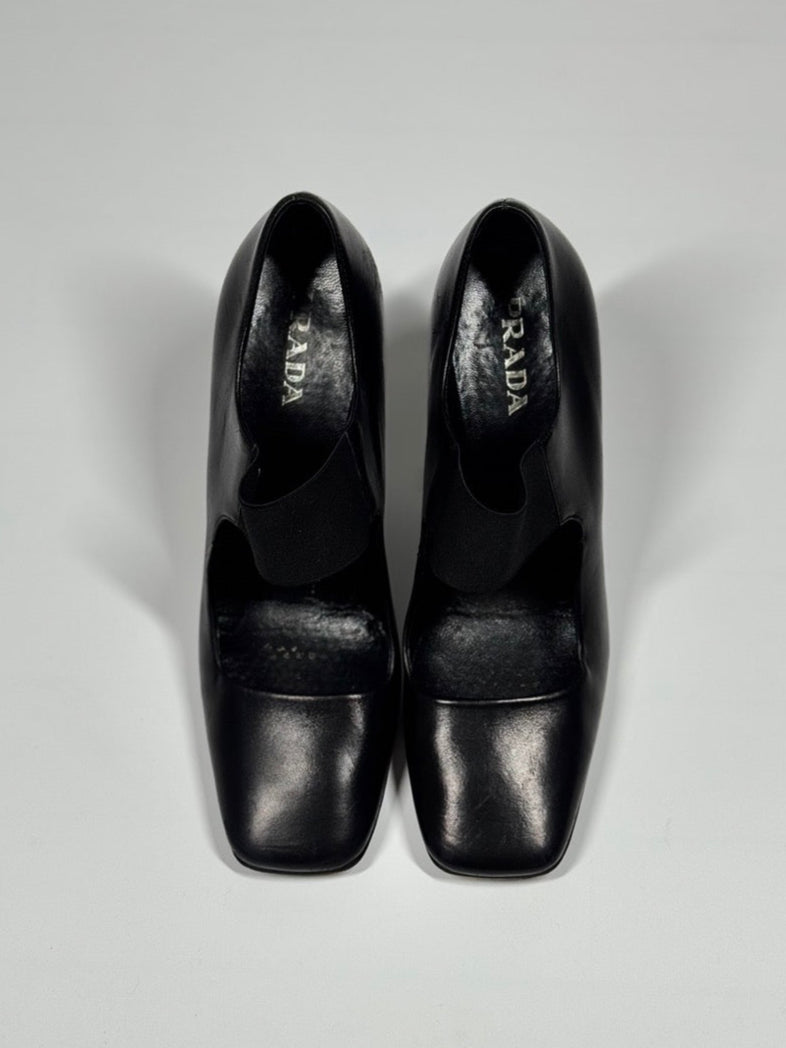 Pair of black high-heeled shoes on a light gray background