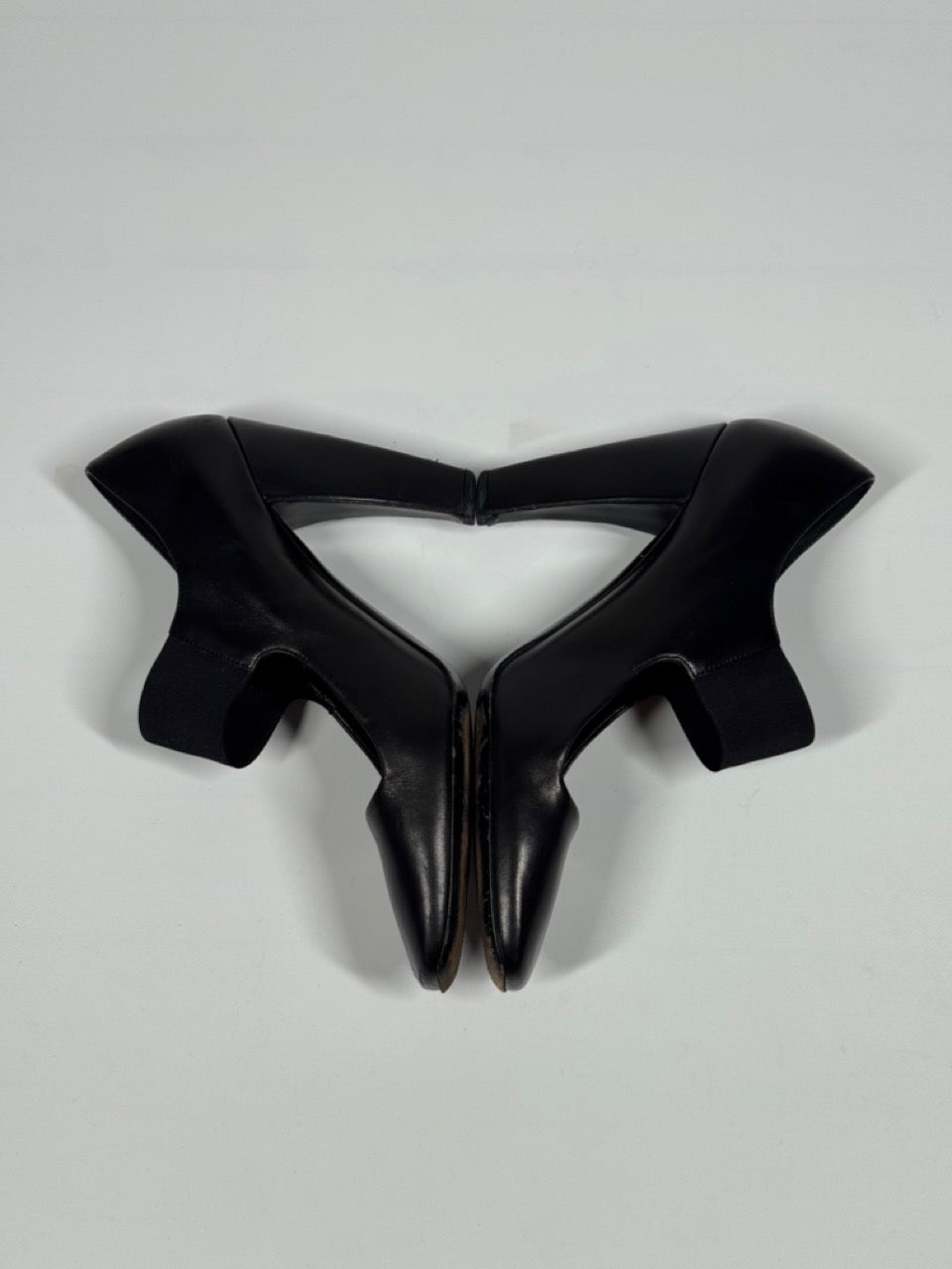 Black high-heeled shoes on a light gray background