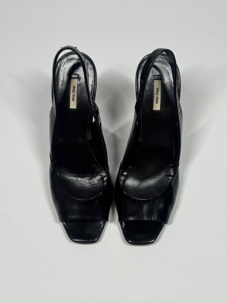 Black wedge sandals on a light gray background