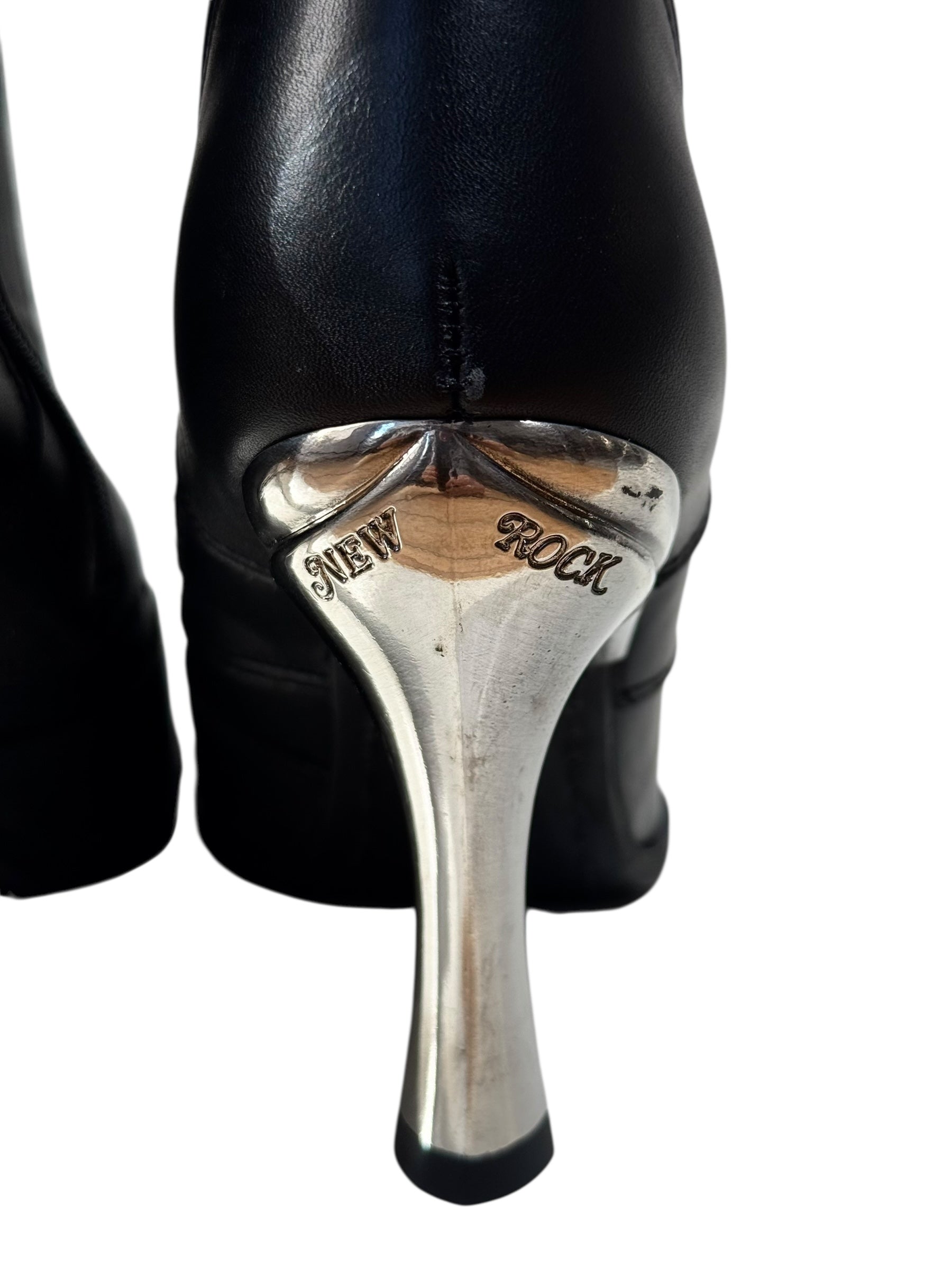 Black high-heeled shoes with silver heel and 'New Rock' branding on a white background