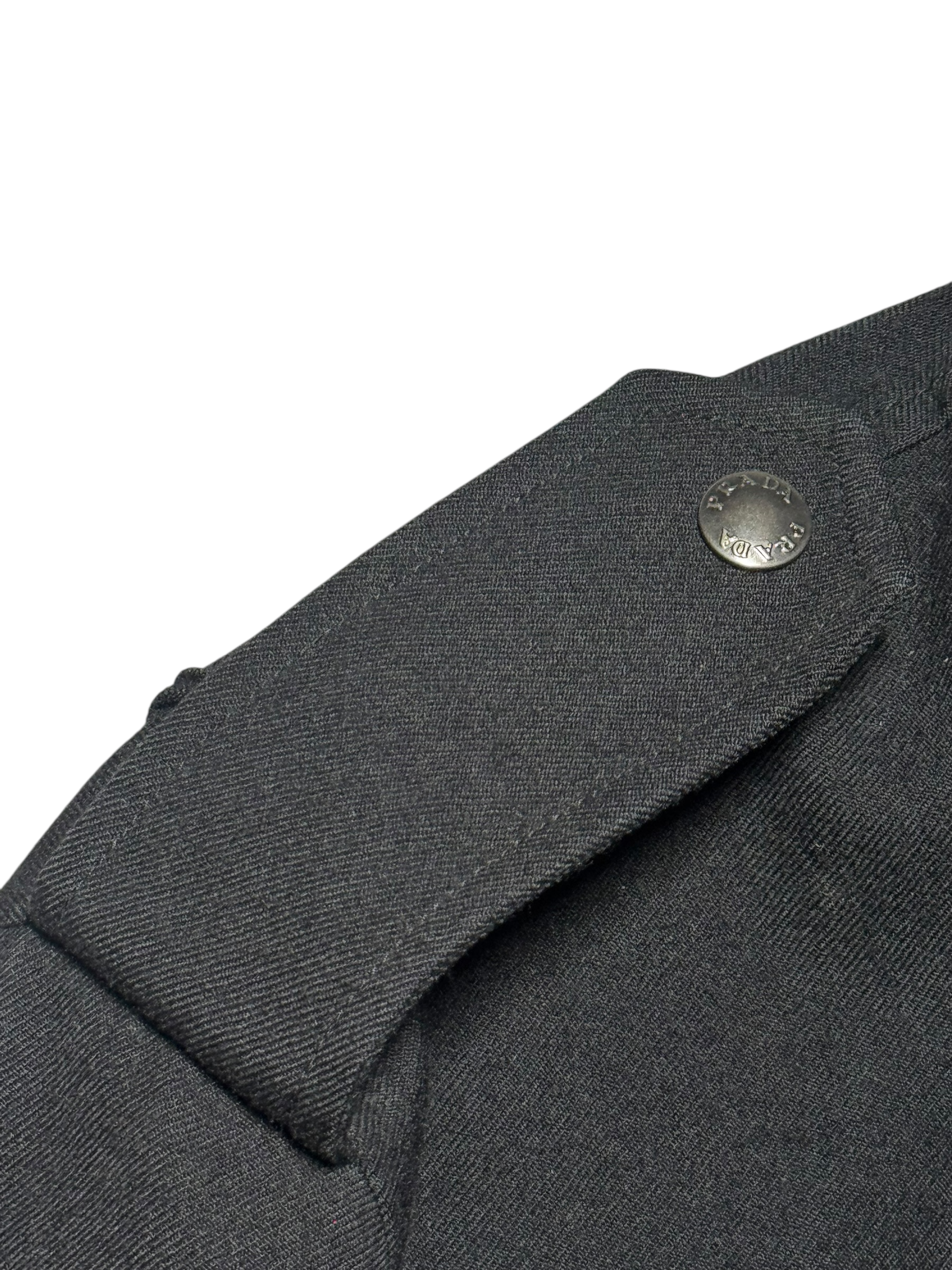 Close-up of a dark gray coat with a button on a white background