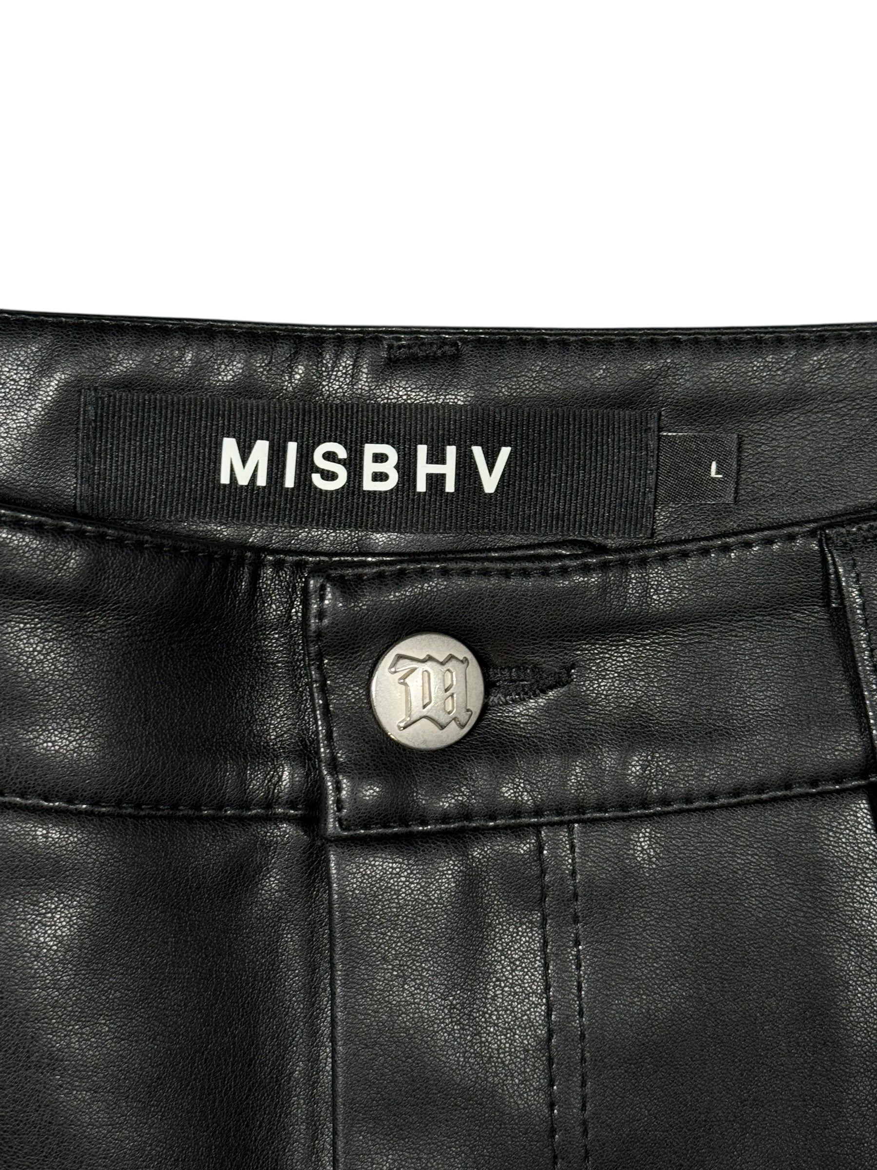 Close-up of black leather pants with 'MISBHV' branding and button detail.