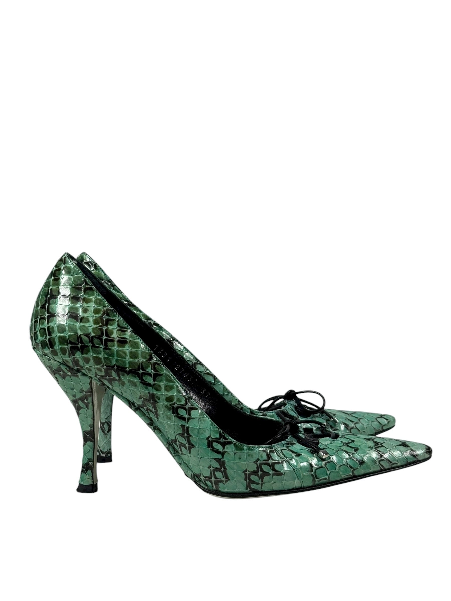 Green high-heeled shoes with snake print on a white background