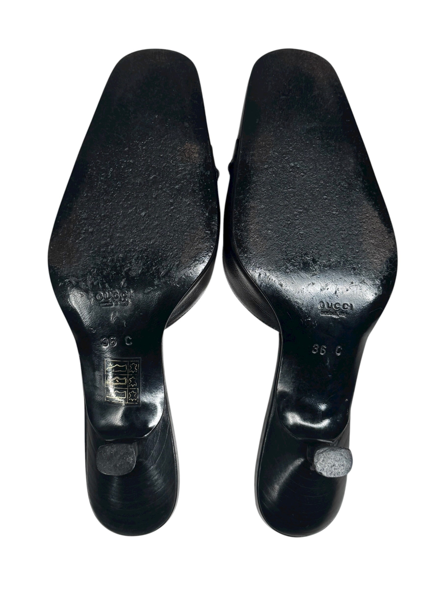 Black shoe soles with visible brand name on a white background