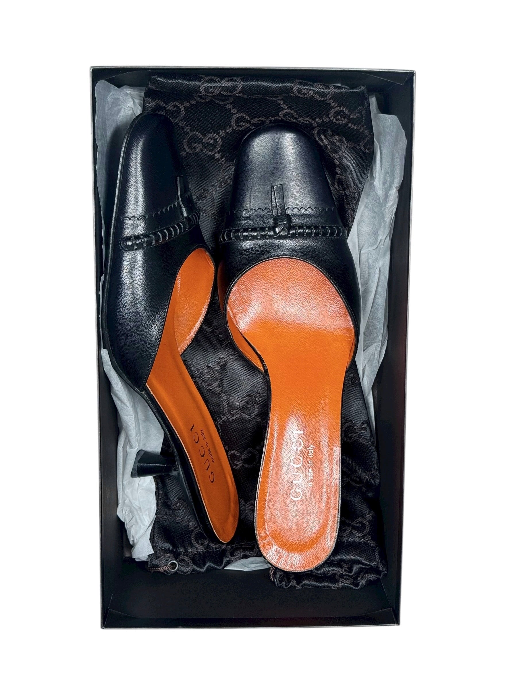Black leather shoes with orange soles in a decorative box