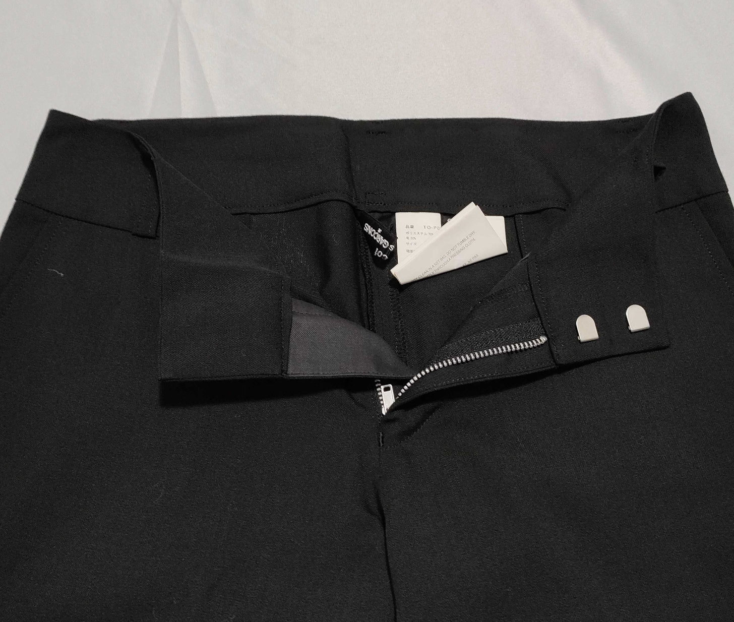 Black jacket with a zipper pocket on a light gray background
